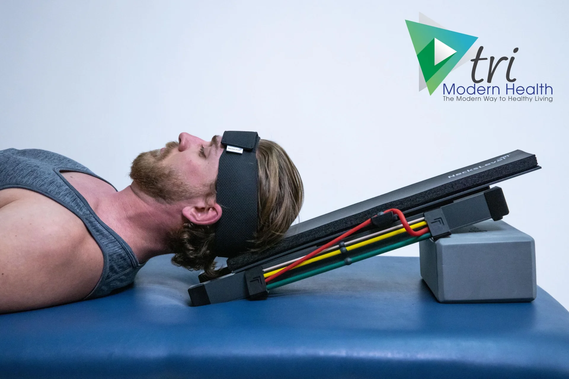 Patient lying on treatment table using NeckLevel11 cervical traction device with resistance bands during chiropractic neck rehabilitation